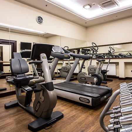 格但斯克，雷迪森布鲁酒店 外观 照片 The photo displays a small gym or fitness room. The room features various exercise equipment, including a treadmill, an elliptical machine, and a set of dumbbells arranged on a rack. There are mirrors on the wall, which help create a sense of space a