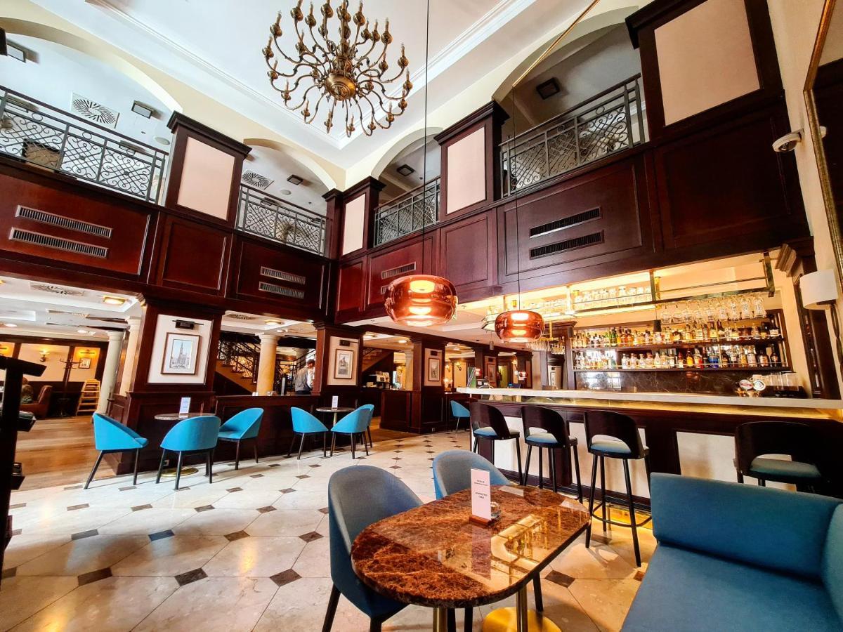 格但斯克，雷迪森布鲁酒店 外观 照片 The photo depicts an elegant interior of a bar or restaurant. It features a high ceiling with a decorative chandelier and wooden paneling, creating a sophisticated atmosphere. The space is well-lit, with a long bar counter visible in the background, 