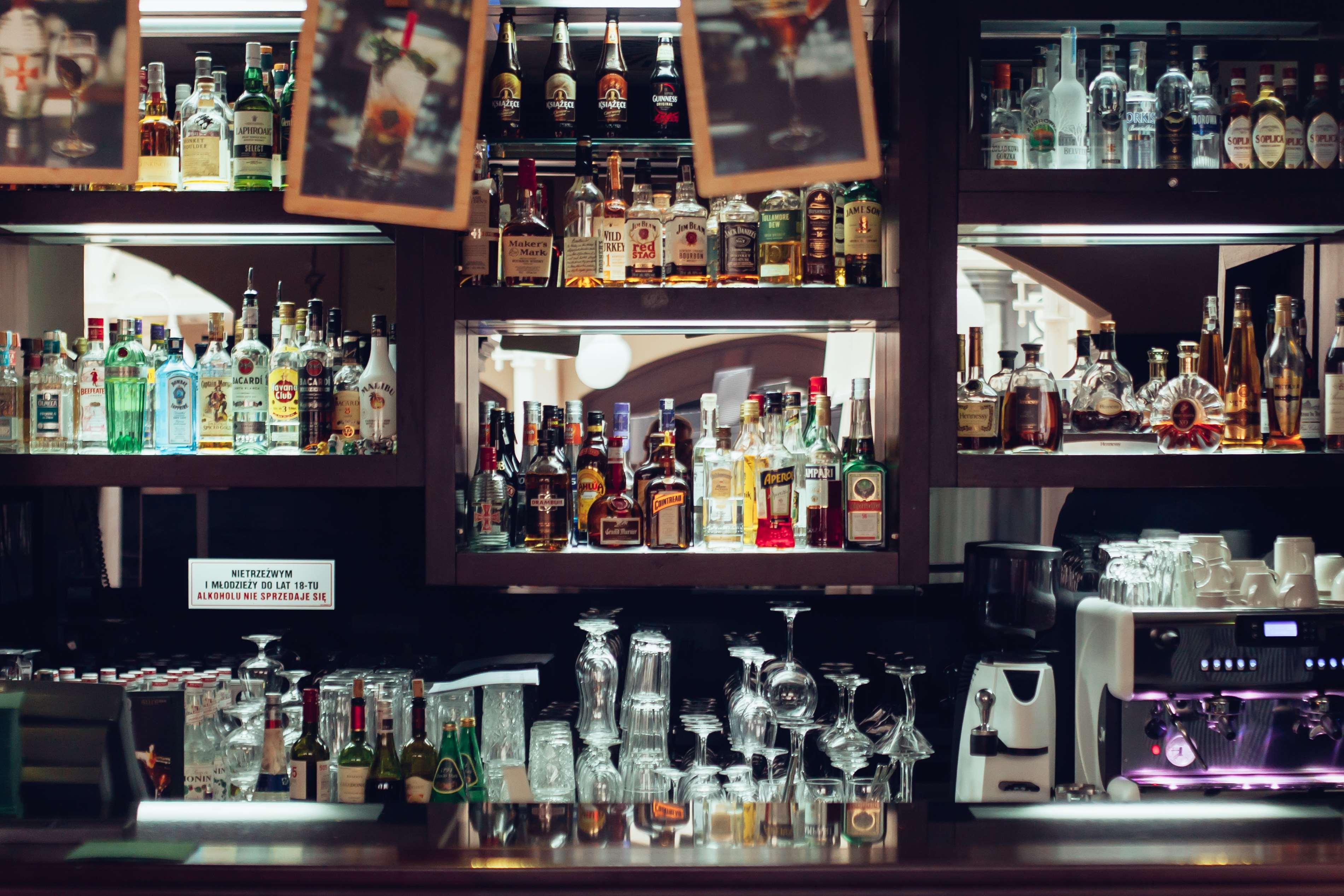 格但斯克，雷迪森布鲁酒店 外观 照片 The photo depicts a bar area featuring a wide variety of alcoholic beverages neatly arranged on shelves. The shelves are filled with bottles of different sizes and colors, including spirits and liquors. In the foreground, there are several glassware 