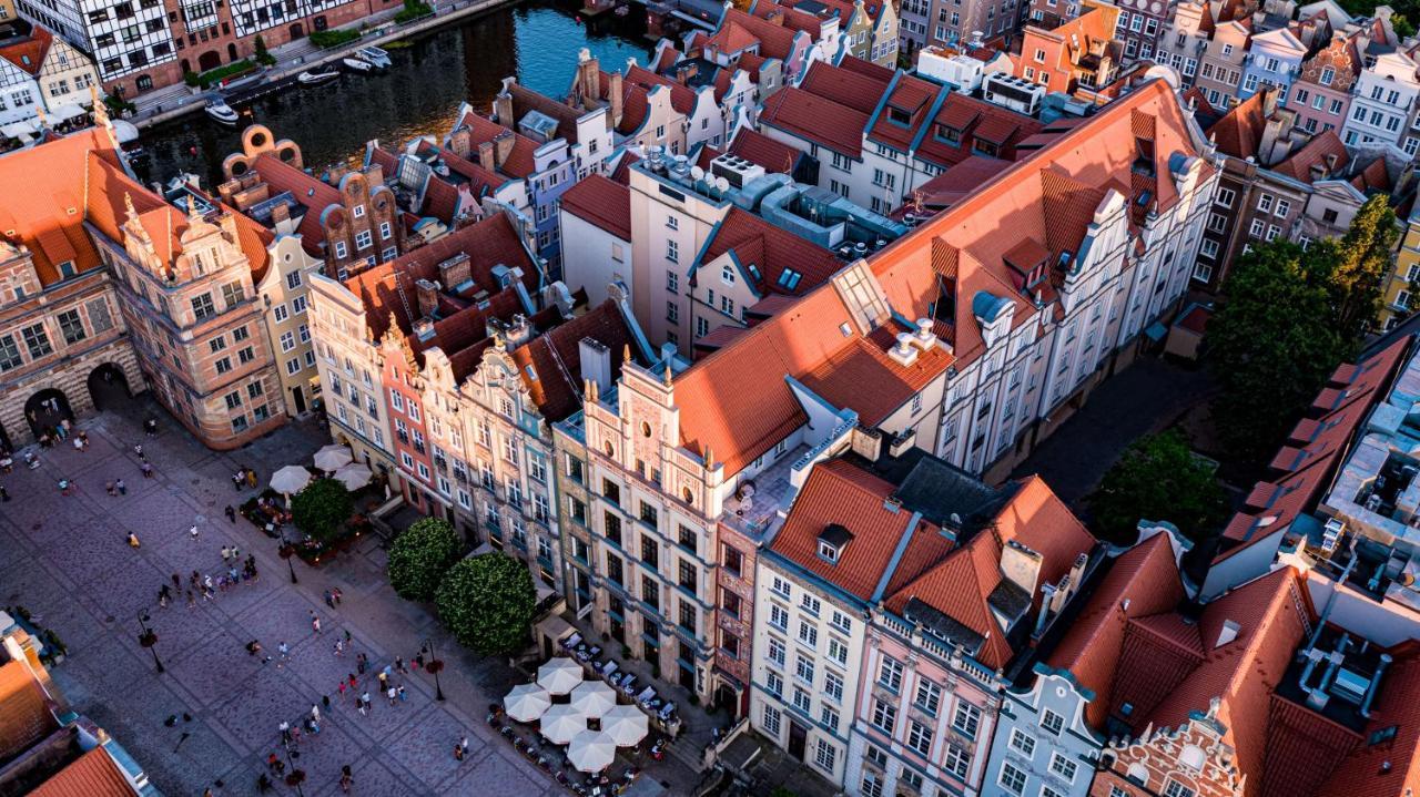 格但斯克，雷迪森布鲁酒店 外观 照片 The photo shows a bird's-eye view of a picturesque urban area, likely in a historical city. It features a cluster of buildings with a mix of architectural styles, characterized by colorful facades and predominantly red rooftops. The buildings seem to